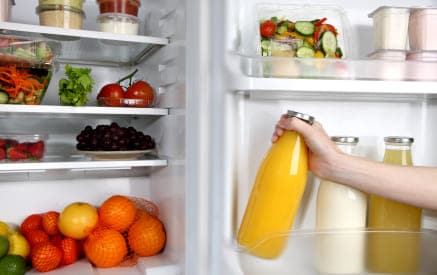 A person keeping mango juice in fridge