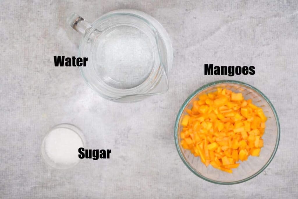 A top view of mangoes cut in cubes a jar of water and sugar