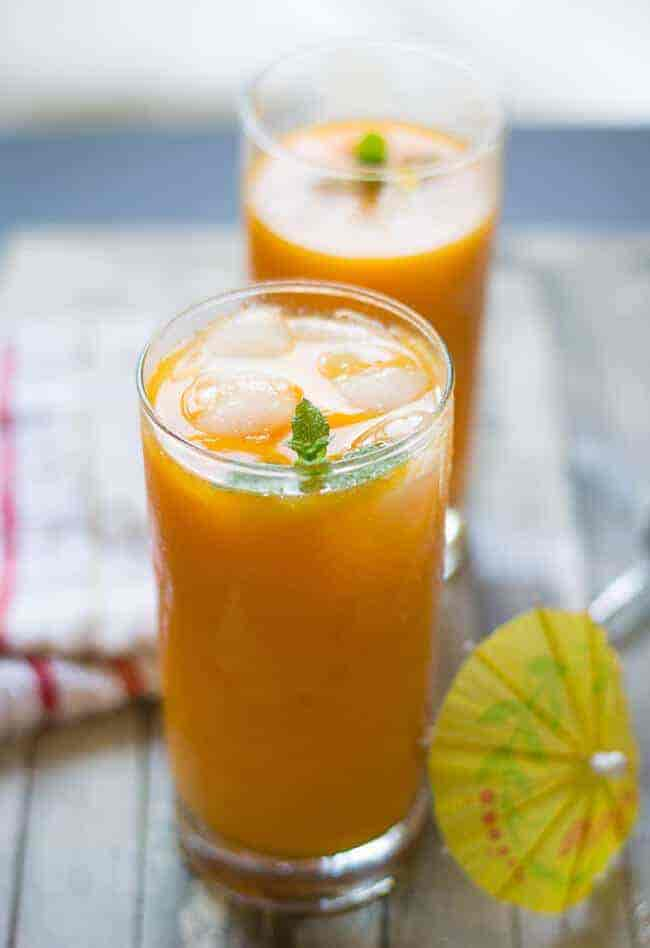 Two glasses of cold mango juice with mint