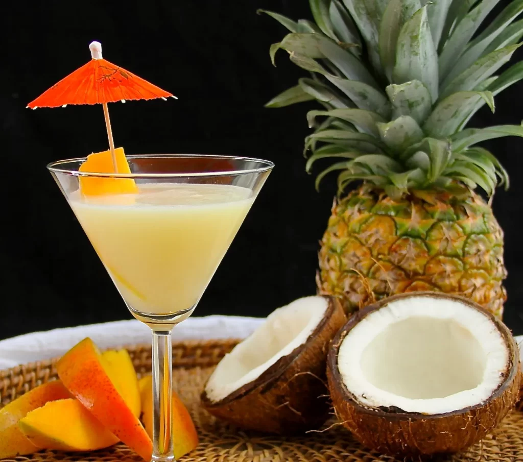 mango and coconut martini glass with pineapple and coconuts