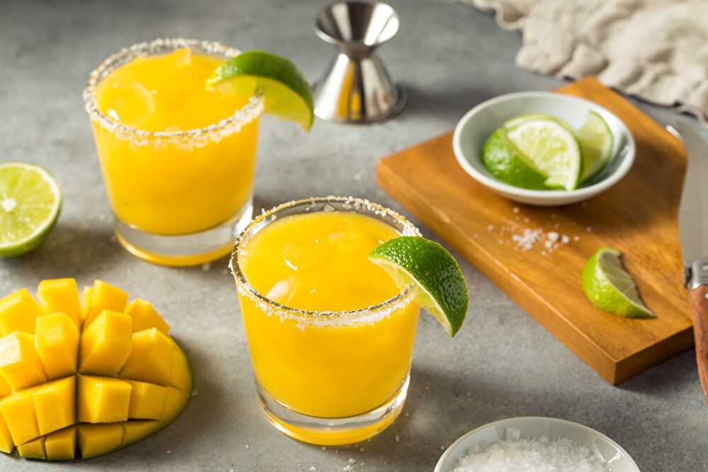 mango tequila served in two rim glasses with lemon wedges on top