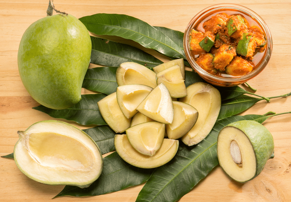 Indian Green mango with pickle on wooden background