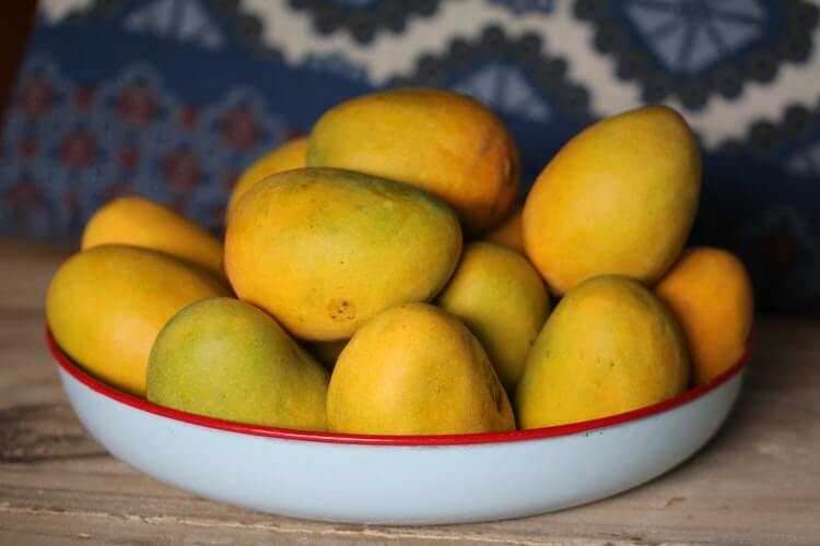 A bunch of mangoes of in a dish