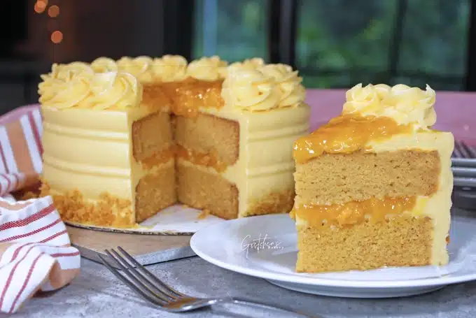 A mango cake with layers of sponge and mango filling topped with buttercream A mango cake with layers of sponge and mango filling topped with buttercream
